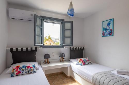 a bedroom with two beds and a window at Traditional Cycladic Home Paros in Naousa