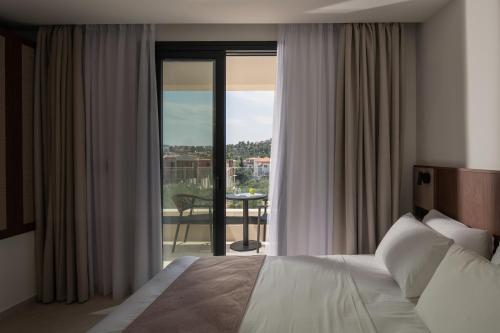 a bedroom with a bed and a view of a balcony at Vista Luxury Suites in Neos Marmaras