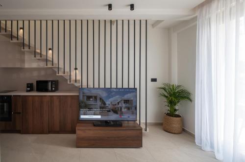 a living room with a tv and a staircase at Vista Luxury Suites in Neos Marmaras