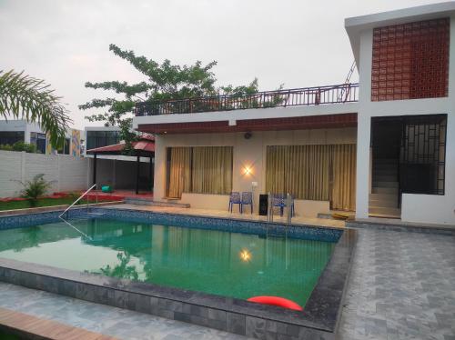 una piscina davanti a una casa di KIMBA FARMS & RESORTS Mangatta a Mūrhīpār