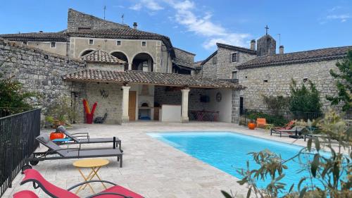 une maison avec piscine devant un immeuble dans l'établissement Gite les Oliviers - Le Domaine du Viticulteur - St Maurice d Ibie, à Saint-Maurice-dʼIbie