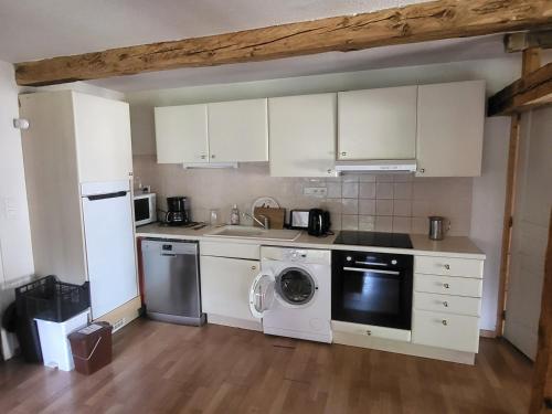 a kitchen with white cabinets and a washer and dryer at Gîte à Molines en Queyras 8-15 pers in Molines-en-Queyras