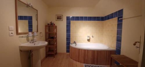 une salle de bain avec une baignoire et un lavabo dans l'établissement Ferme de la Haute Maison Maison d hotes, à Saint-Loup-de-Naud
