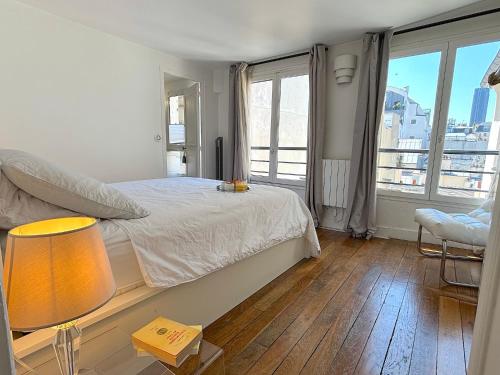une chambre avec un lit et une table avec une lampe dans l'établissement L'appartement Colombier, à Paris