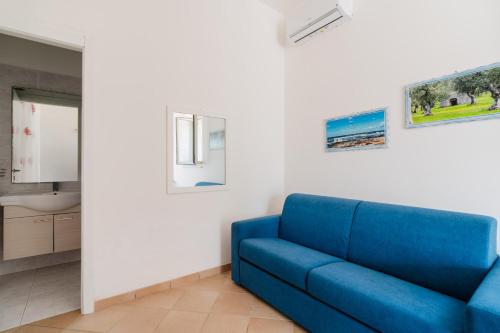 a blue couch in a room with a bathroom at Casa Vacanza Plautilla - Salento Selection in Maglie