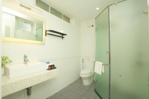 a bathroom with a sink and a toilet and a shower at The Mira Villa West Lake by XÔI Residences in Hanoi