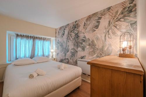 - une chambre avec un lit et un mur orné d'une fresque murale dans l'établissement Entre Thiers et Vous - HyperCentre, à Grenoble