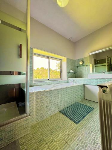 une salle de bain avec une baignoire, un lavabo et une fenêtre dans l'établissement Maison de Charme avec Piscine - Le Cocon de La Bastide, à La Bastide-de-Sérou