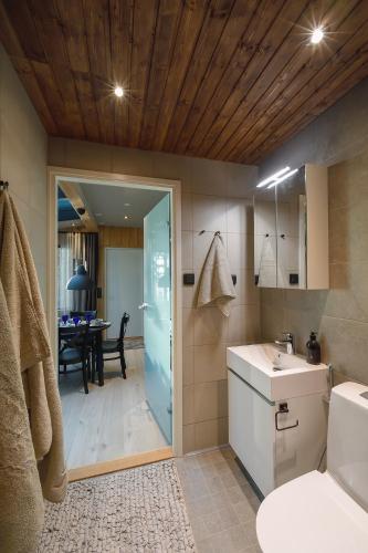 a bathroom with a sink and a toilet and a table at Northern Lights Village Saariselkä in Saariselka
