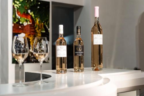 three bottles of wine sitting on a table with wine glasses at Château les Crostes in Lorgues