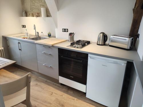 une cuisine avec une cuisinière et un évier dans l'établissement Centre Historique de Caen, à Caen