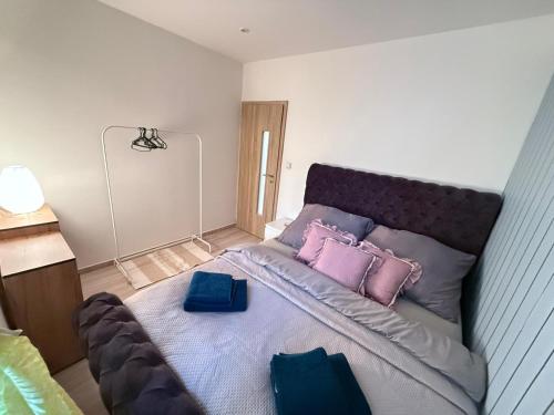 a bedroom with a large bed with pink and purple pillows at Komenského free parking in Olomouc