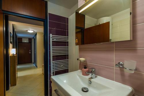 um banheiro com uma pia e um espelho em Apartment Many em Pula