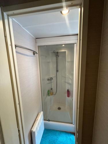 une salle de bain avec une douche avec une porte vitrée dans l'établissement Mobil-home 6 personnes 2CH 44m2, à Arreau