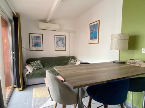 un salon avec un canapé vert et une table dans l'établissement T2 en entrée de Cassis, à Cassis