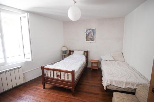 une chambre avec deux lits et une fenêtre dans l'établissement Maison sur la rivière, à La Celle-sous-Gouzon