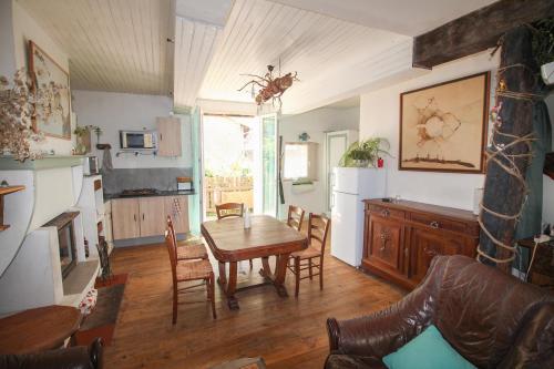 une cuisine et une salle à manger avec une table et des chaises dans l'établissement Maison sur la rivière, à La Celle-sous-Gouzon