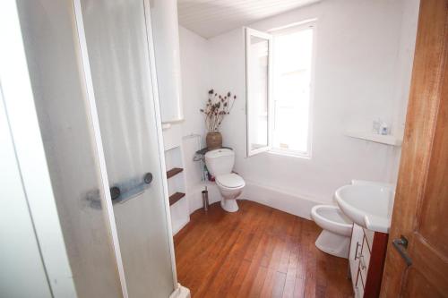 une salle de bain avec toilettes, lavabo et fenêtre dans l'établissement Maison sur la rivière, à La Celle-sous-Gouzon