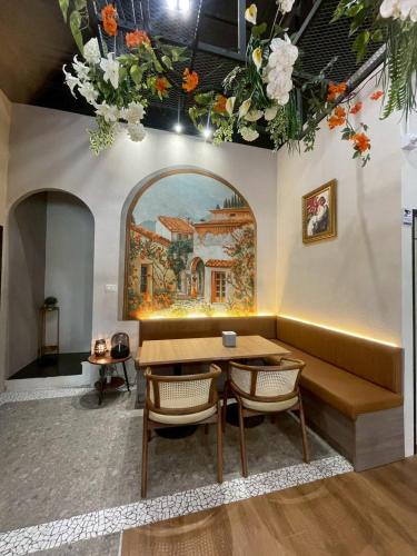 a dining room with a table and a painting on the wall at Diff Apartel Banglamphu in Bangkok