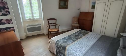 une chambre avec un lit, une chaise et une fenêtre dans l'établissement Madeleine, à Sancerre