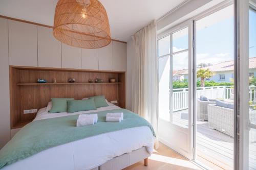 una camera da letto con un letto grande e un balcone di Villa Les Peupliers avec piscine privée et sauna a Royan