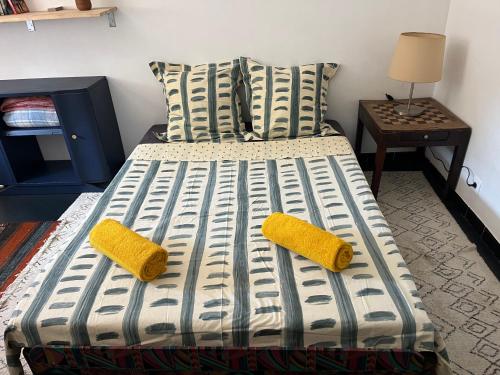 un lit avec deux oreillers et deux serviettes jaunes dessus dans l'établissement La Loggia, à Sète