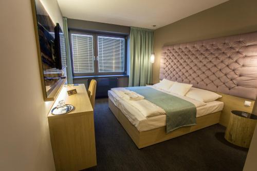 a hotel room with a bed and a table at Onyx Luxury in Sárvár