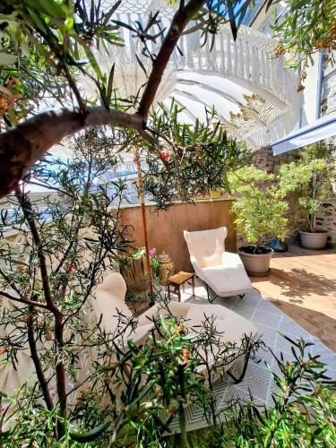 un jardin intérieur avec une chaise blanche et des plantes dans l'établissement Maison 1949, à Saint-Sauveur-le-Vicomte