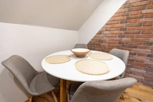 a dining room with a white table and chairs at Gris Apartment in Gornja Radgona