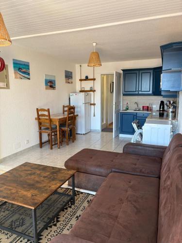 un salon avec un canapé et une table et une cuisine dans l'établissement Appart en RDC avec grandre terrasse sur la Marina, à Saint Cyprien Plage