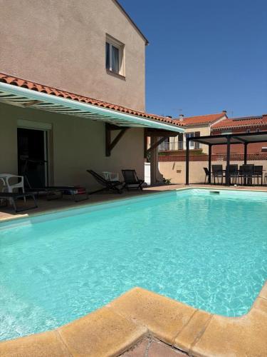 une grande piscine devant une maison dans l'établissement Villa avec piscine a 6 min du port Saint-Cyprien, à Saint Cyprien Plage