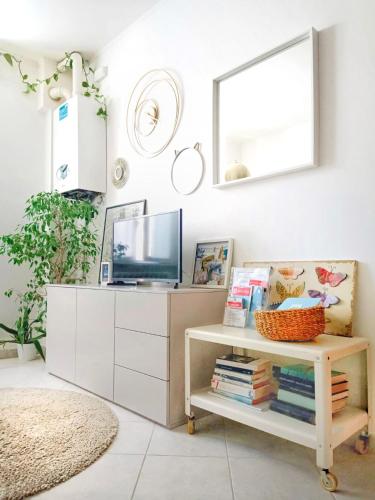 a living room with a tv and a shelf with books at A casa di Pizz - Bilocale con parcheggio privato in Savona