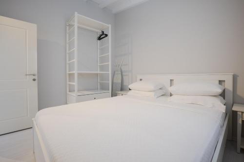 a white bedroom with a white bed with white pillows at AEGEAN Apartments - Marina & Chios Island View in Cesme