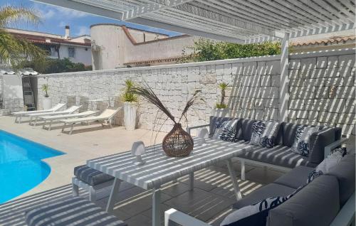 a patio with a table and chairs next to a pool at 1 Bedroom Awesome Home In Leporano in Leporano
