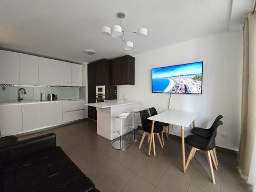 une cuisine avec des armoires blanches et une table et des chaises dans l'établissement Nice Riquier 8, à Nice