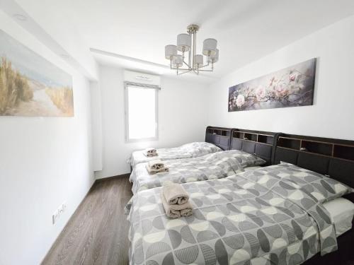 deux lits dans une chambre aux murs blancs dans l'établissement Nice Riquier 8, à Nice