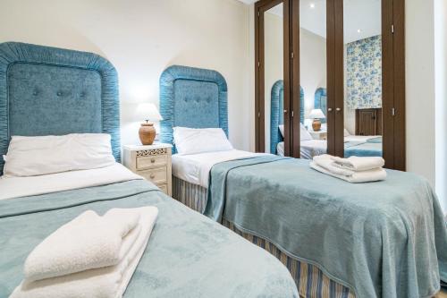 a bedroom with two beds and a mirror at BP7C.2A Beachfront Penthouse with Private Pool in Estepona