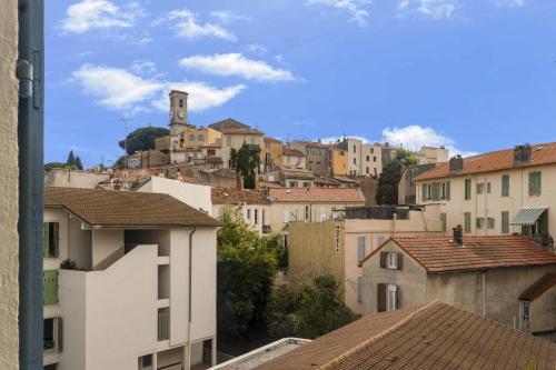 - une vue sur une ville avec des maisons et une tour d'horloge dans l'établissement Spacieux 4 chambre Forville, à 5 minutes du palais, à Cannes