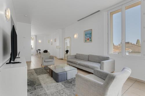un salon avec un canapé et une télévision dans l'établissement Spacieux 4 chambre Forville, à 5 minutes du palais, à Cannes