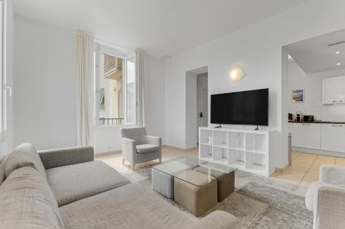 un salon avec un canapé et une télévision à écran plat dans l'établissement Spacieux 4 chambre Forville, à 5 minutes du palais, à Cannes