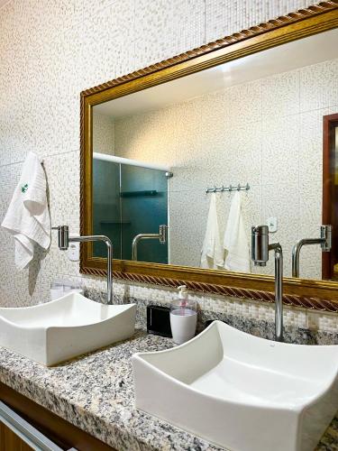 a bathroom with two sinks and a large mirror at Casa Atalaia Paraíso in Atalaia