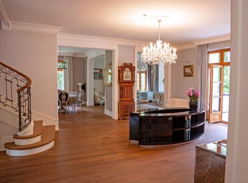 a living room with a staircase and a chandelier at Stately Home in Magdalenka Warsaw in Magdalenka