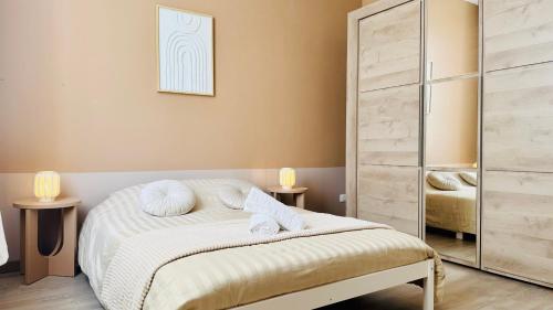 une chambre avec un lit avec des serviettes dessus dans l'établissement L'Instant Bohème - Parking - Proche gare & Wifi, à Sainte-Savine