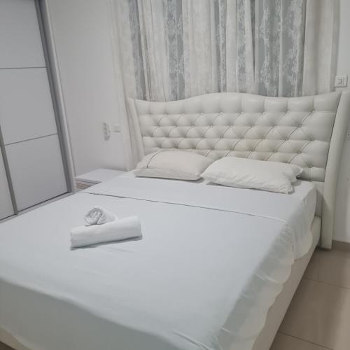 a bedroom with a white bed with a large mirror at Royal park LUXURY apartment in Eilat