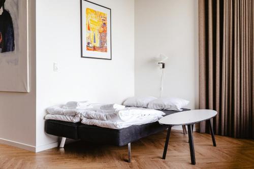 a bed in the corner of a room with a table at Danish Design By Helnæs' Edge in Ebberup