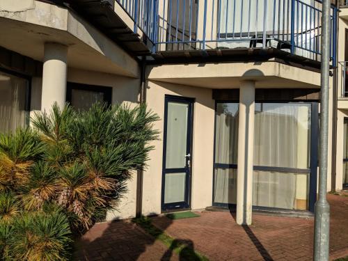 a building with a glass door and a balcony at Taikos 7 in Nida