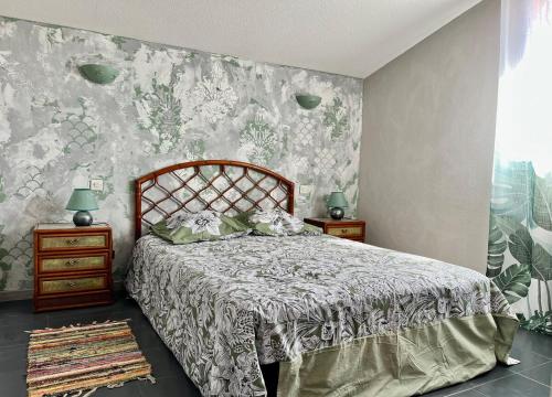 - une chambre avec un lit et un mur fleuri dans l'établissement Charming mediterranean house, à Villelongue-de-la-Salanque