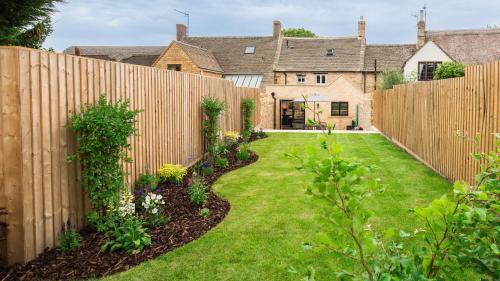 a fence in a garden with a yard at Primrose Cottage in Chipping Campden