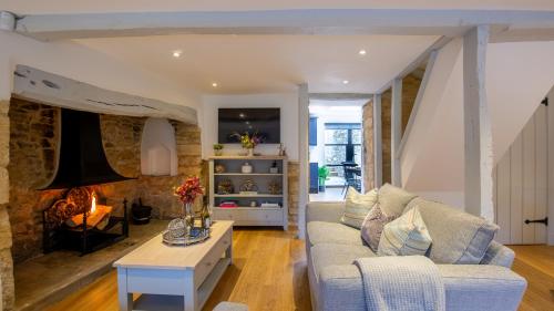 a living room with a couch and a fireplace at Primrose Cottage in Chipping Campden