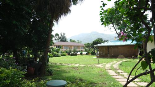 a yard with a house and a building at The Riverstone Agro Farm in Vajapūr